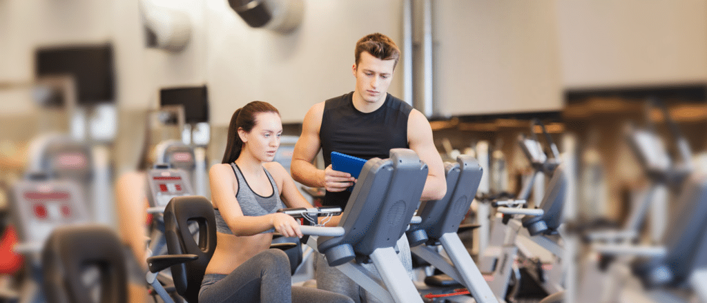 Gym Trainer with Client on Bike