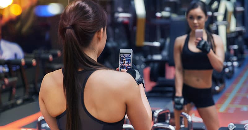 Woman at gym taking mirror selfie