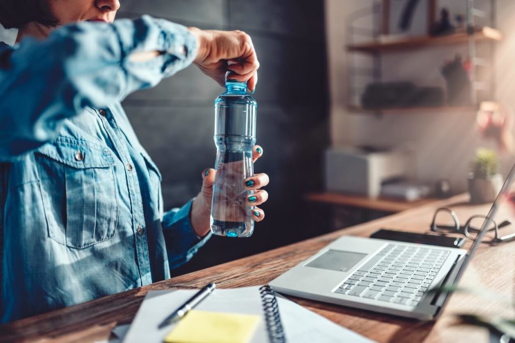 Person with water bottle and computer