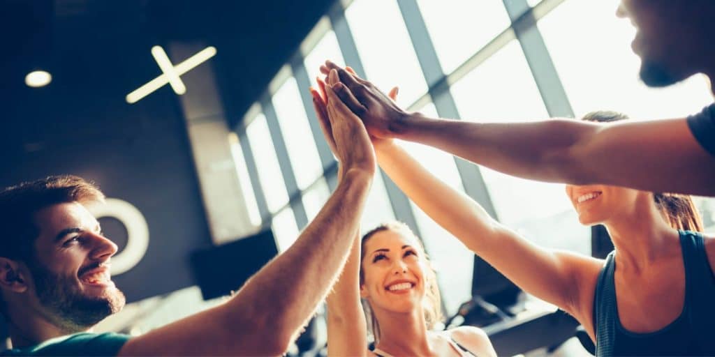 Team high five in a gym. 