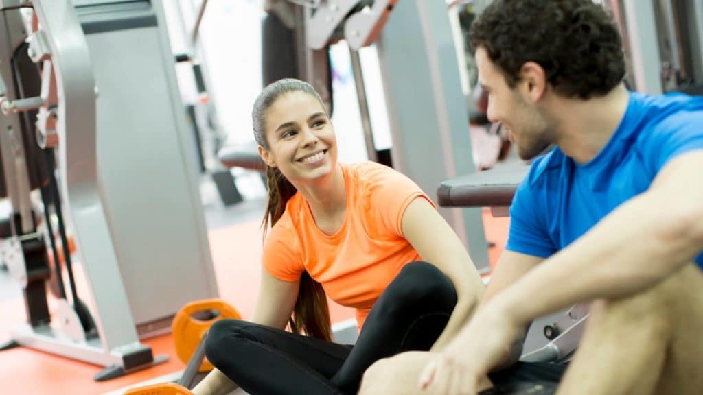 woman and man in a gym smiling