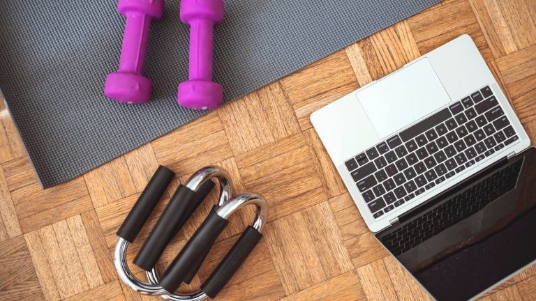 laptop, weights, and yoga mat on the floor