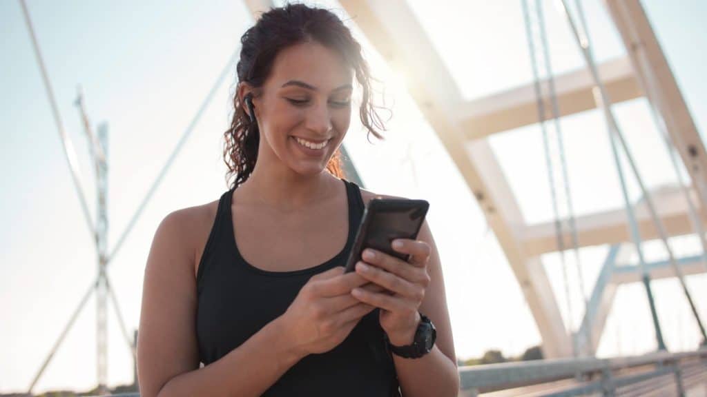 Fitness woman on her phone. 