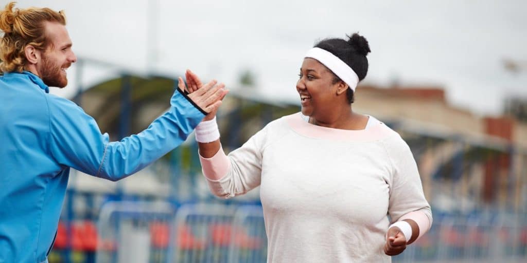 Personal trainer high fiving client during a workout.